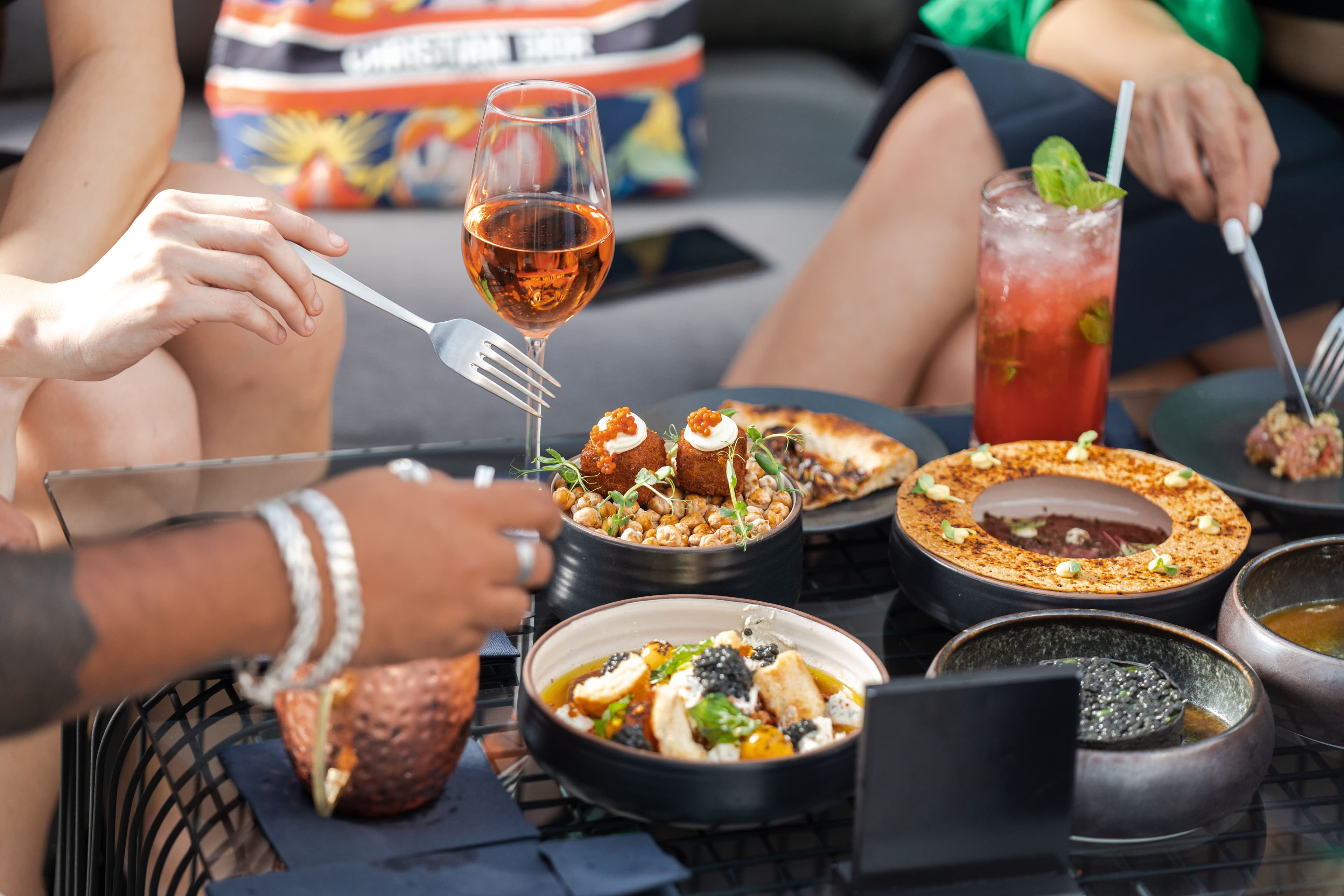 Elevated al fresco dining table with plated dishes and cocktails