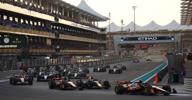 Formula 1 cars racing off the start line at a Grand Prix