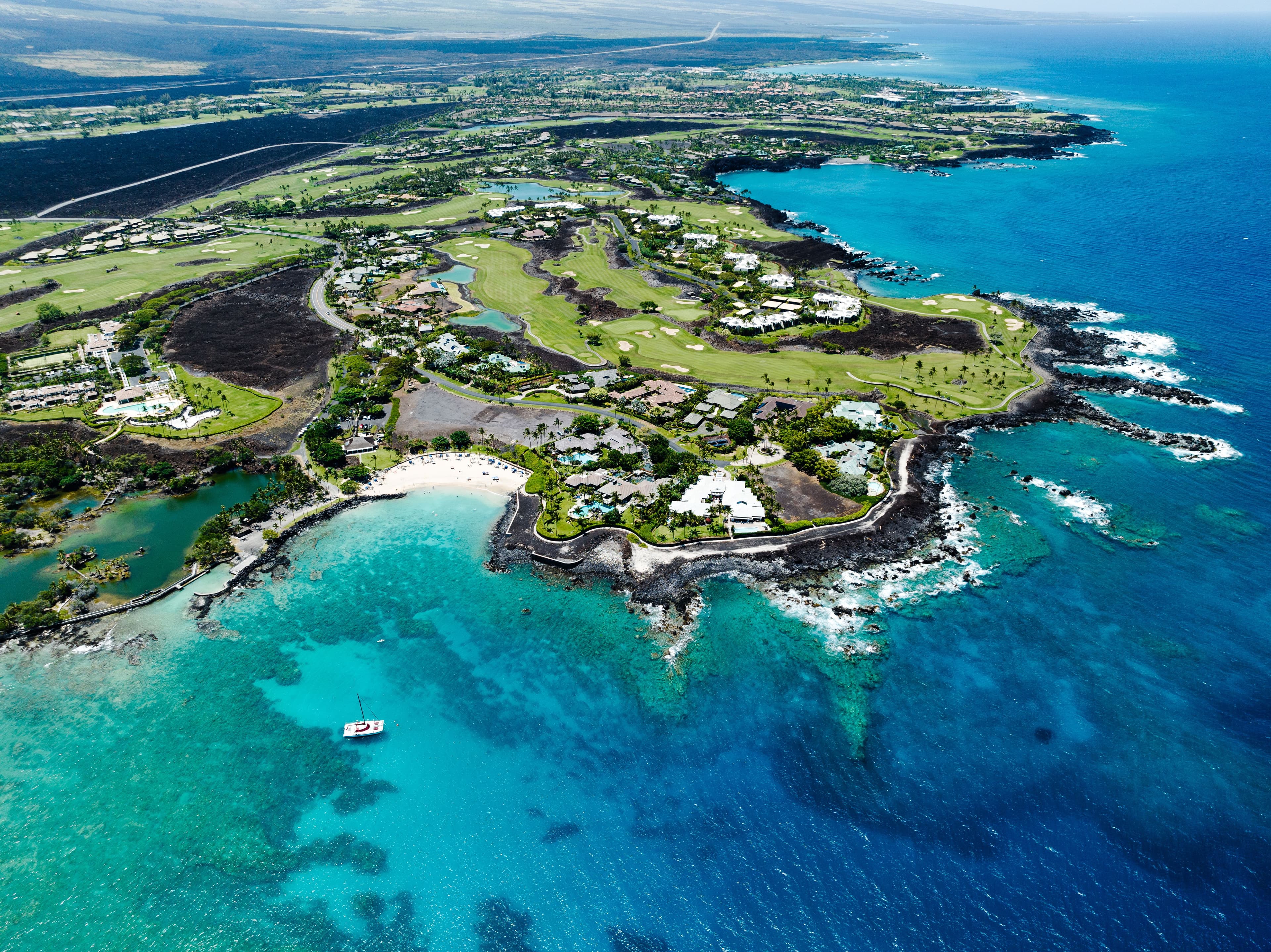 Aerial view of a coastal golf resort overlooking turquoise water