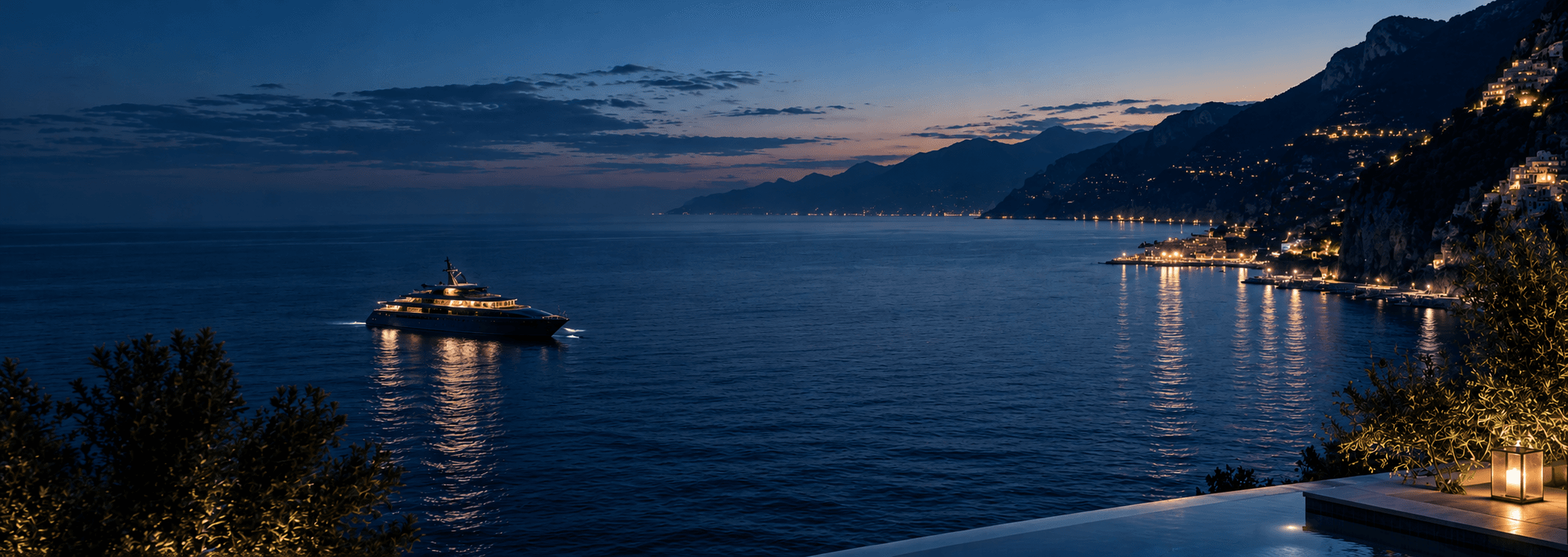 Superyacht cruising the Amalfi coastline at nightfall
