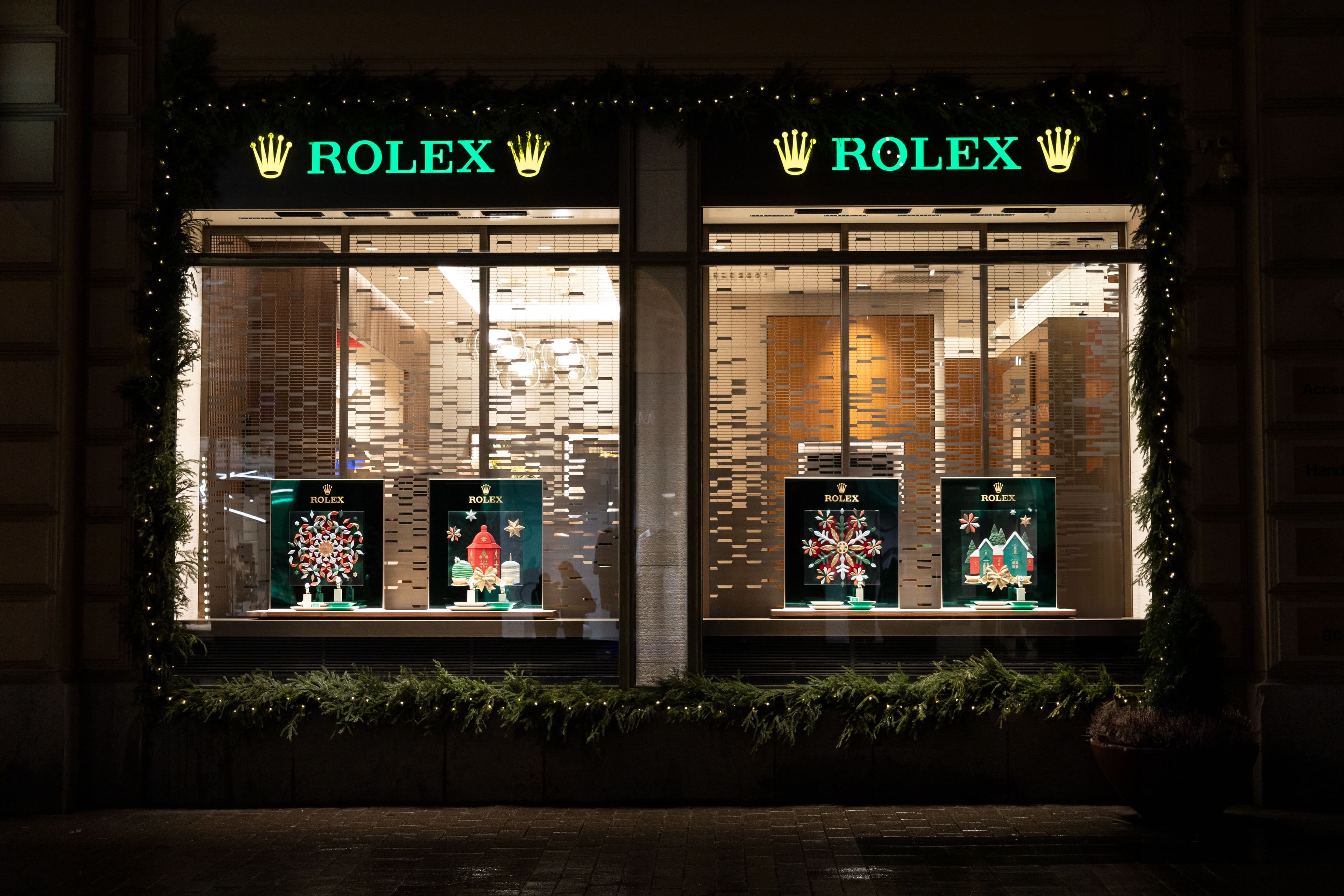 Illuminated Rolex boutique storefront at night